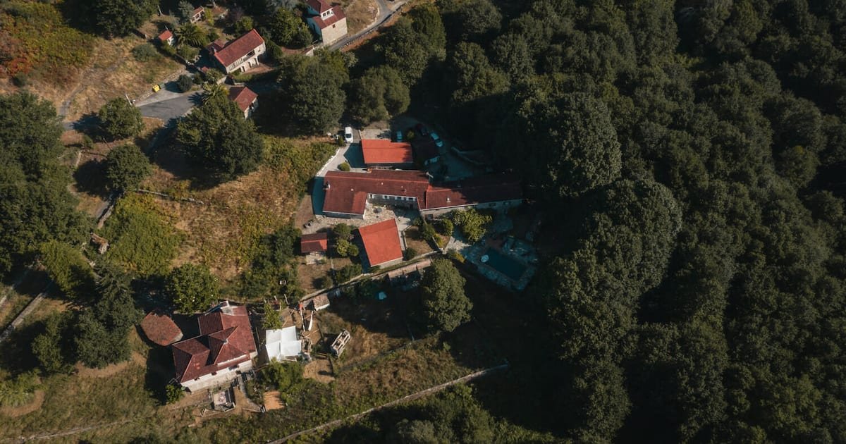 Vista aérea de Anceu Coliving en Ponte Caldelas: casas de piedra, patio y entorno rural