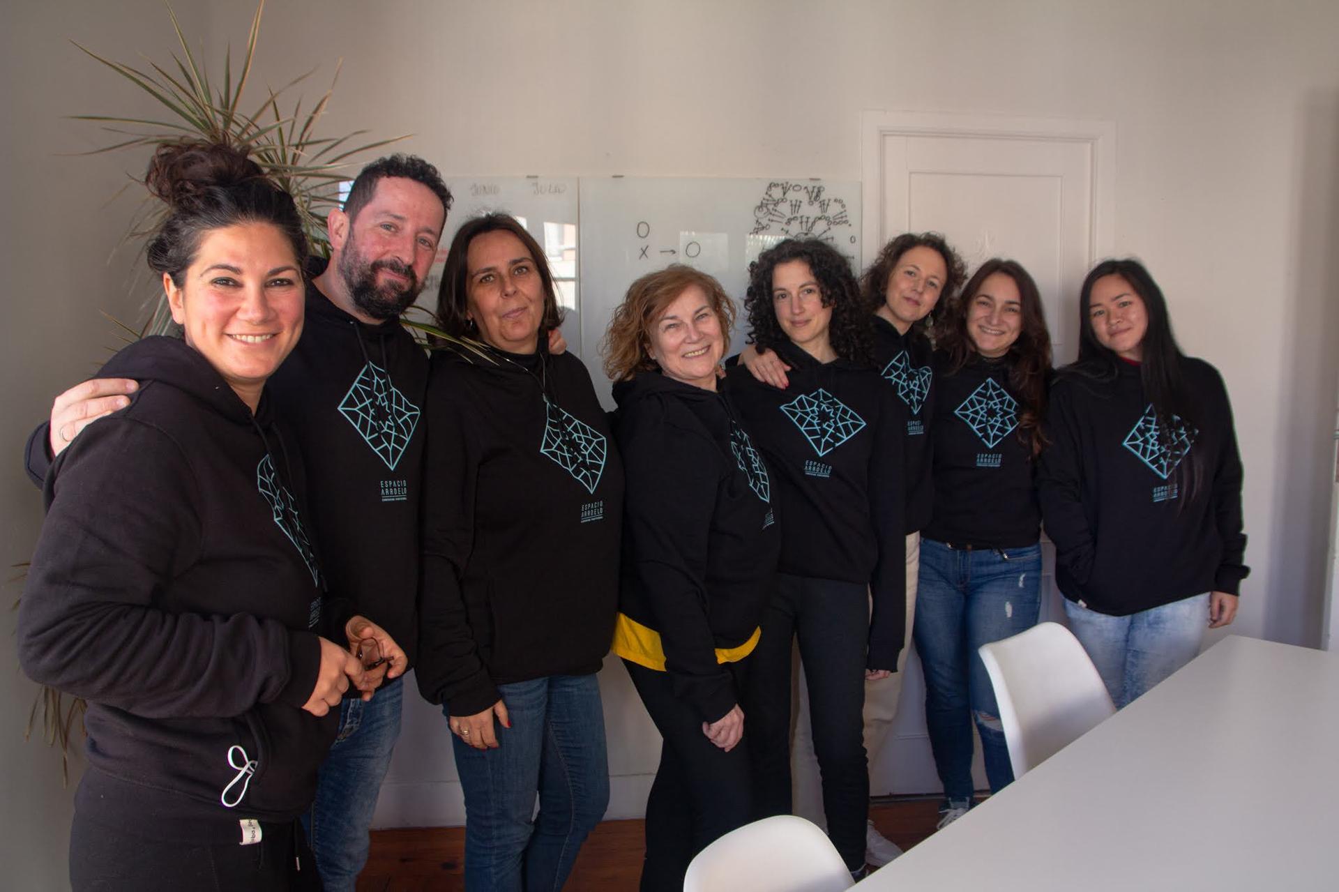 Comunidad de Espacio Arroelo con sudaderas del coworking de Pontevedra frente a una pizarra