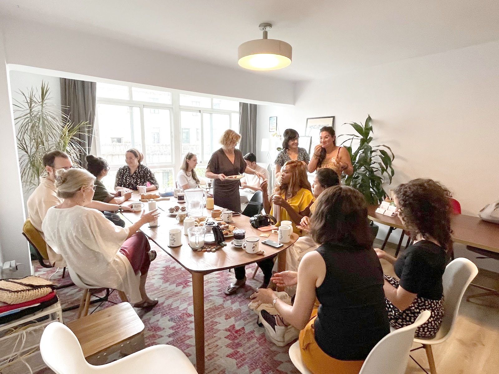 Comunidad reunida alrededor de la mesa del salón de Espacio Arroelo en Pontevedra