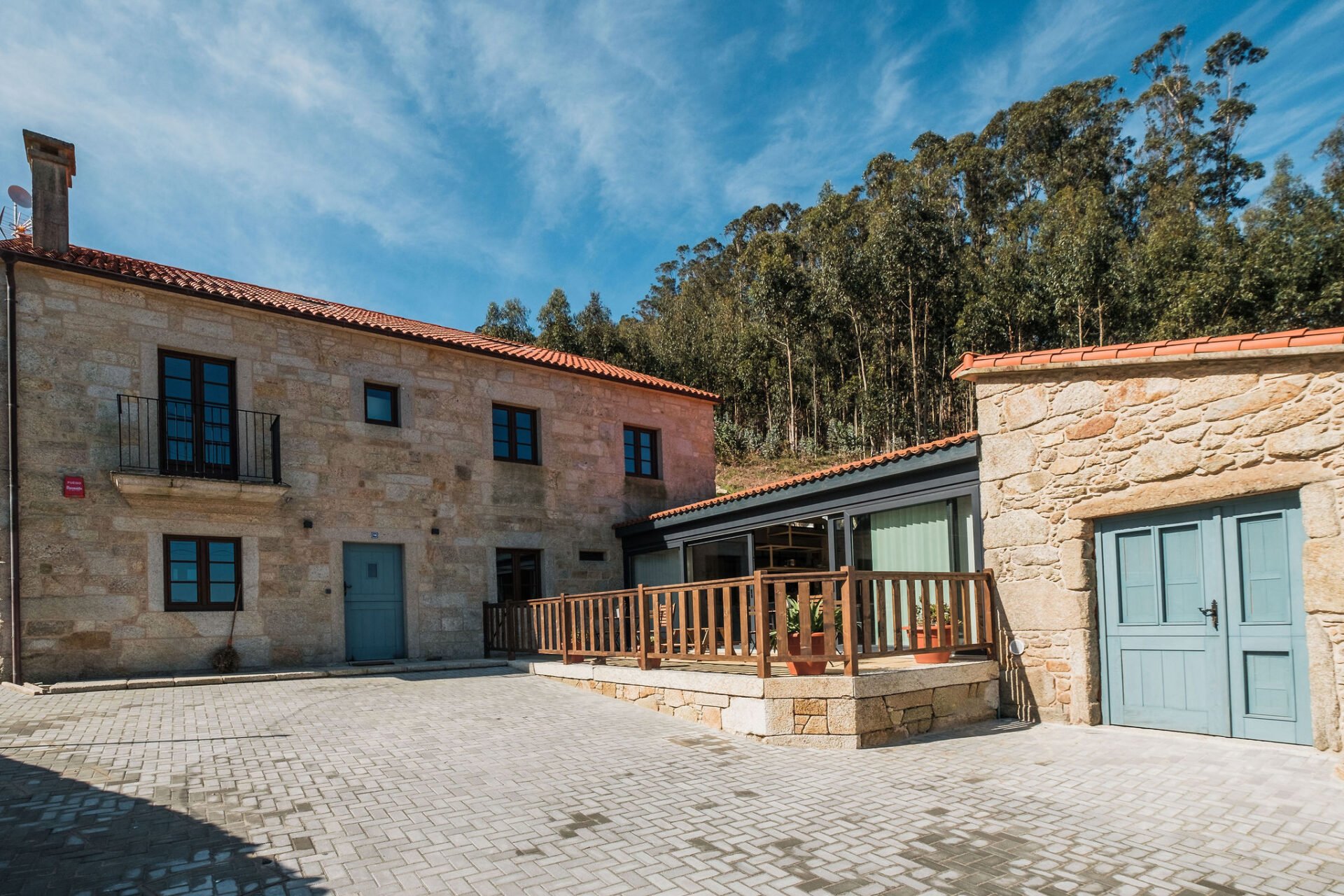Casa de piedra de iSlow Coliving en Laxe (Costa da Morte), con puertas azules y terraza