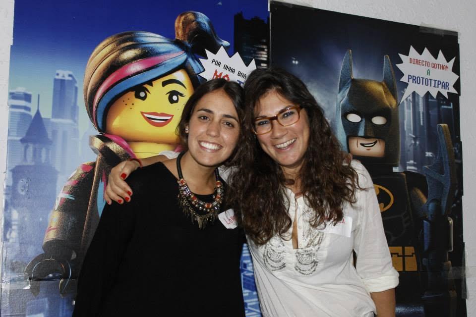 Dos participantes sonriendo delante de carteles LEGO con el lema Directo a prototipar