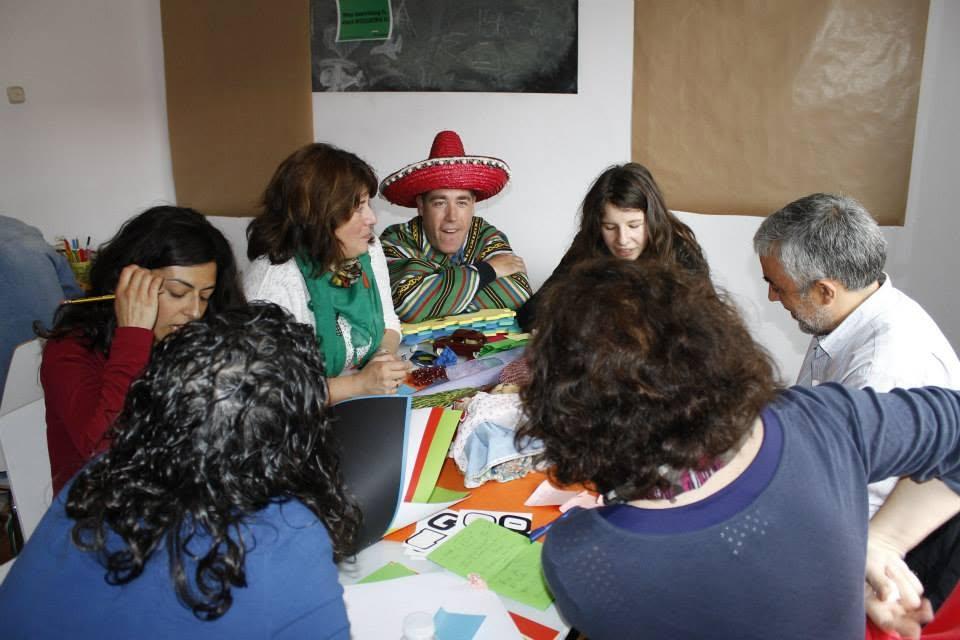 Equipo alrededor de la mesa de prototipado con materiales de colores y un participante con sombrero mexicano