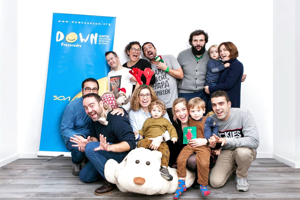 Comunidad de Down Pontevedra Xuntos y Espacio Arroelo junto al banner de la asociación, en un momento lúdico en el coworking