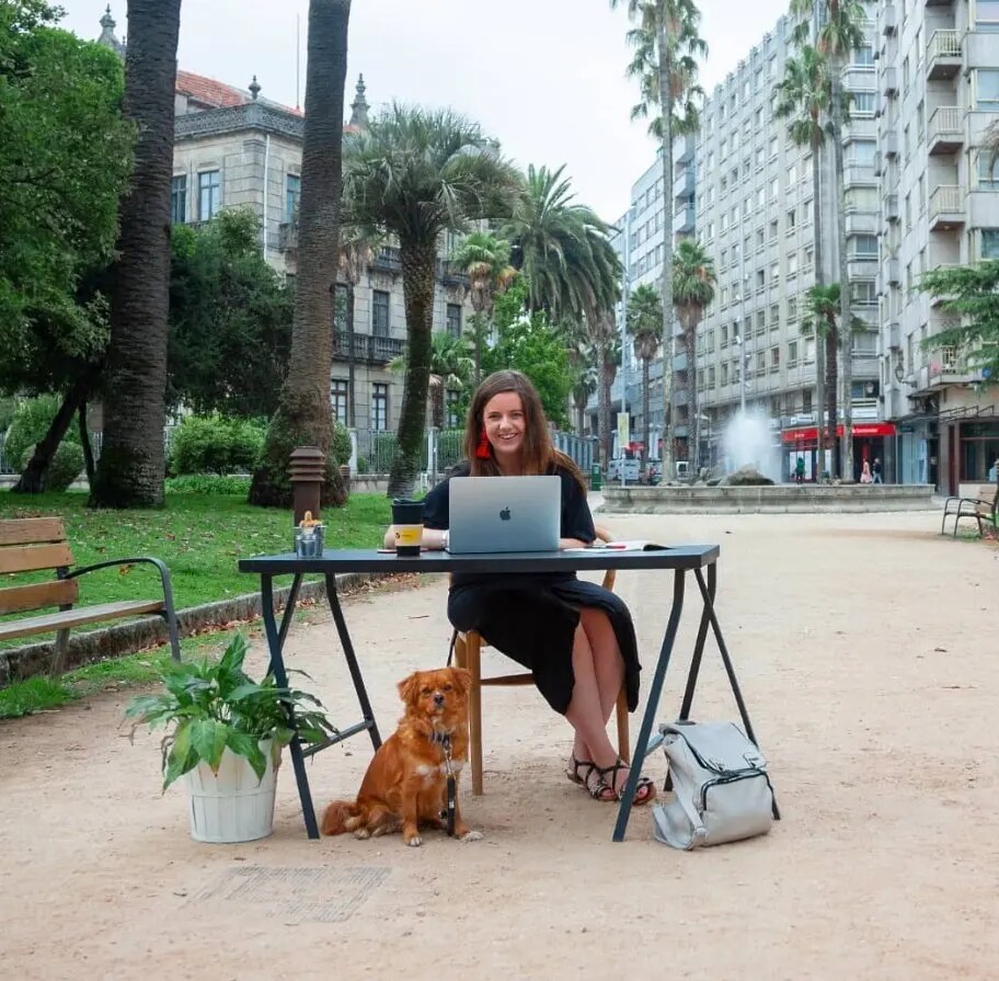 Coworker con su perro trabajando al aire libre en una plaza de Pontevedra