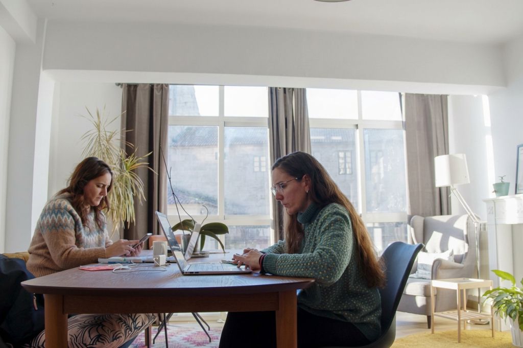 Dos coworkers trabajando con portátil en la mesa del salón