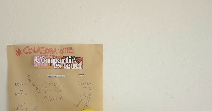 Papel kraft en la pared con #COLABORA 2015, «Compartir es tener» y nombres de participantes escritos a boli