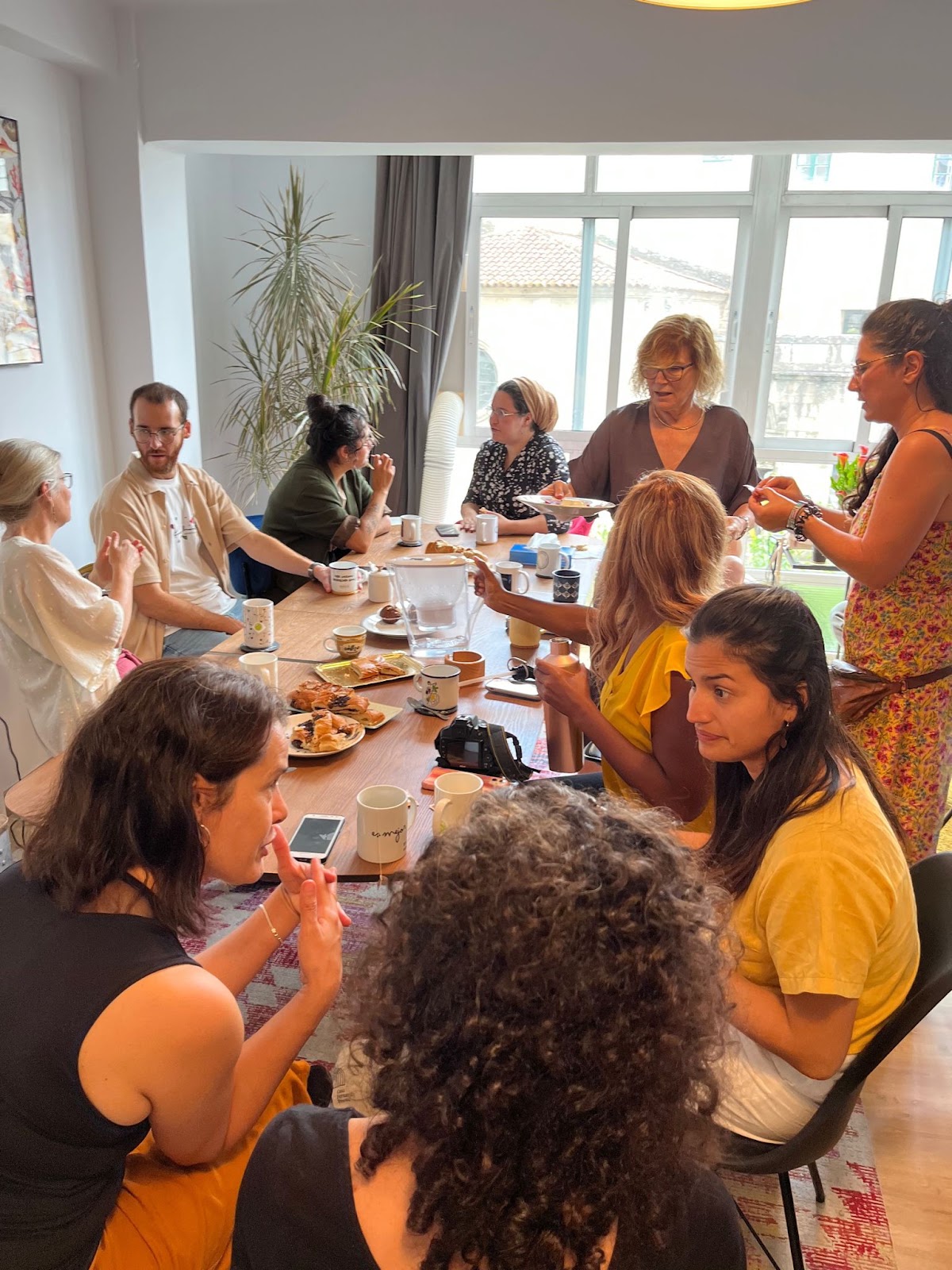 Comunidad de coworkers desayunando en la mesa del salón de Espacio Arroelo