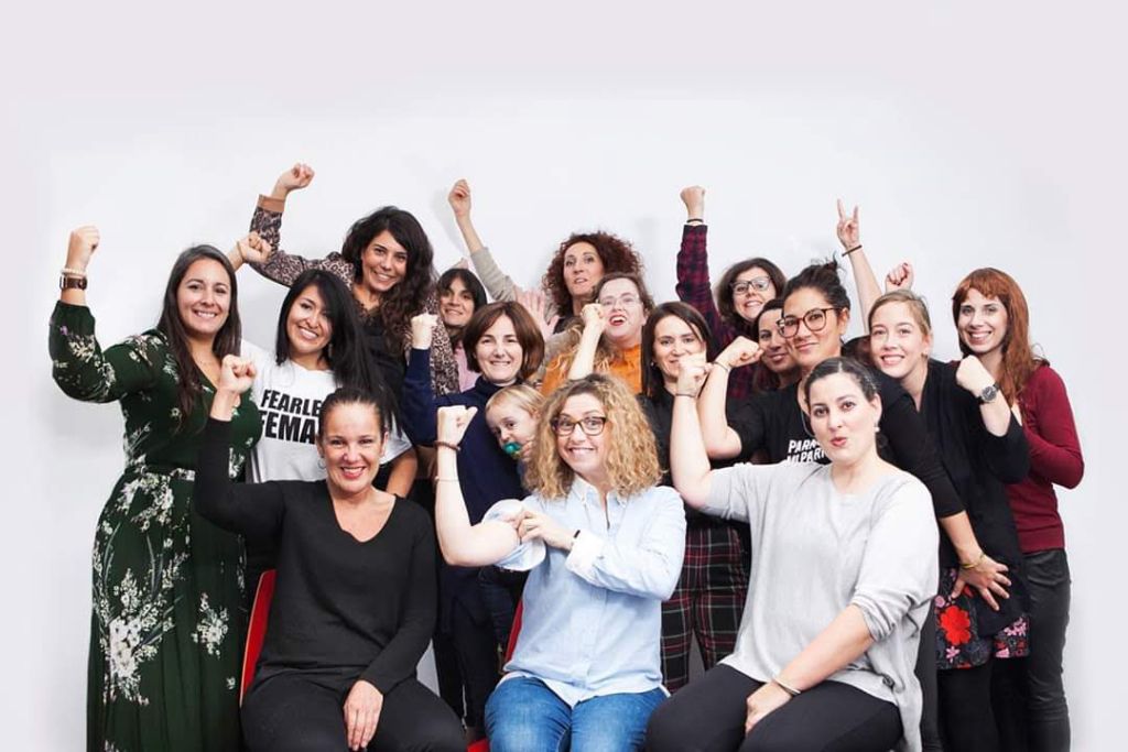 Grupo de mujeres de la comunidad Arroelo posando con fuerza; una lleva la camiseta Fearless Female