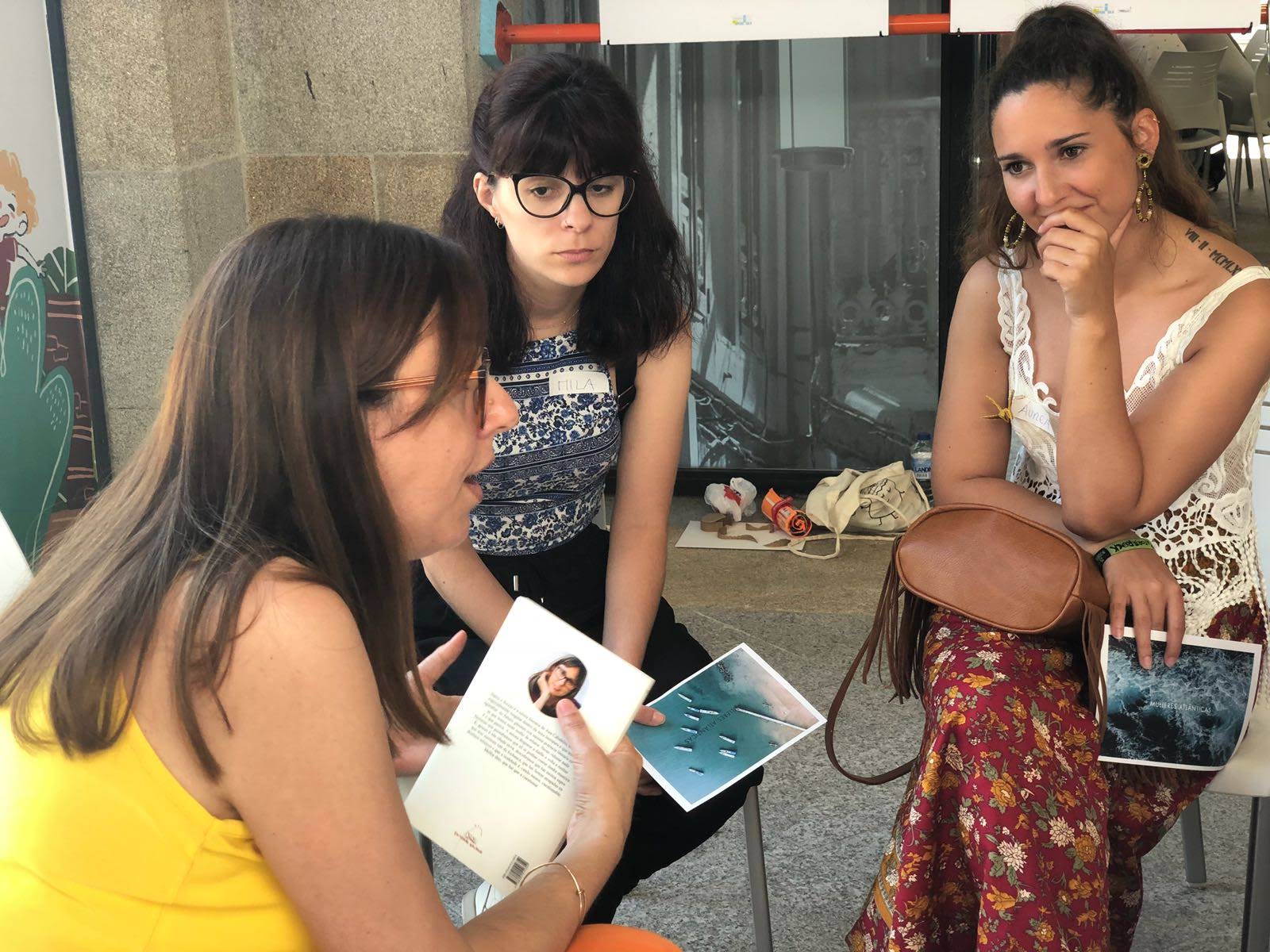 Tres mujeres en diálogo con fotos y materiales de Mulleres Atlánticas