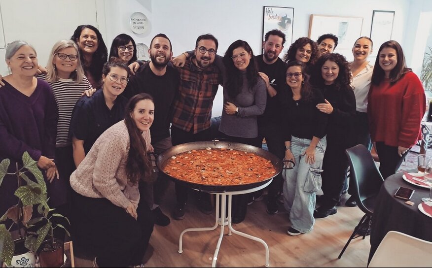 Grupo de la comunidad de Espacio Arroelo alrededor de una paella compartida