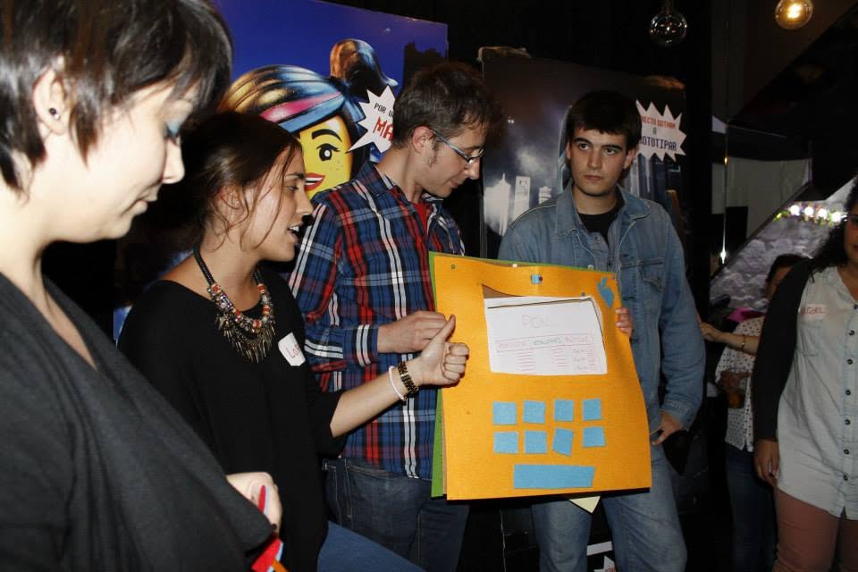 Equipo mostrando un prototipo de fieltro naranja con gesto de pulgar arriba durante PonteJam