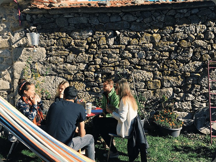 Grupo conversando junto a una casa de piedra en Sende, Senderiz (Lobeira)
