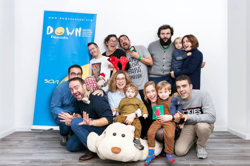 Grupo de Down Pontevedra Xuntos y Espacio Arroelo junto al banner de la asociación, en un momento lúdico